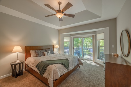 Primary bedroom with one king bed and sliding glass doors leading to the outdoor deck