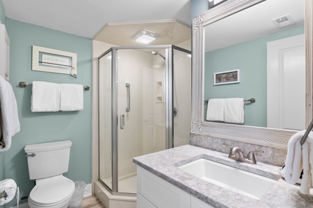 Your spa-like bathroom features a spacious glass shower, elegant marble countertops, and fresh towels awaiting your arrival.
