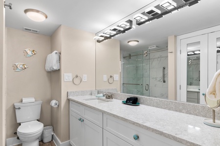 Refresh in your spacious bathroom with modern fixtures, walk-in shower, and coastal touches that bring beachside tranquility indoors.