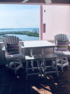 Relax on your private balcony with sweeping water views, a bridge stretching across the horizon, and comfortable seating perfect for morning coffee or sunset watching.