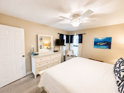 Your peaceful retreat features a plush bed, coastal decor, and nautical accents that invite relaxation. Unwind under the ceiling fan after a day exploring local beaches.
