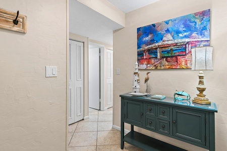 Step into your welcoming entryway where vibrant artwork and thoughtful touches create an inviting first impression of your coastal retreat.
