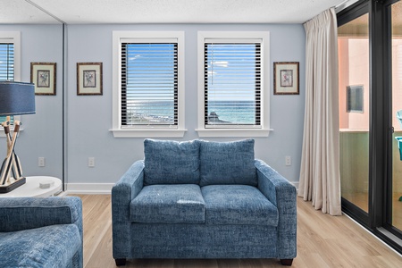 Sink into the soft blue sofa and take in the stunning ocean views through your windows. The calming coastal palette and natural light create a peaceful retreat you'll never want to leave.