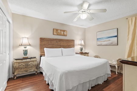 Sink into fresh linens on your comfortable bed in this serene coastal-inspired bedroom, complete with a ceiling fan to keep you cool and warm wood floors underfoot.