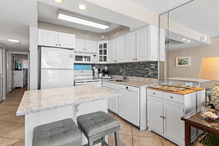 Your fully equipped kitchen features granite counters, modern appliances, and elegant white cabinetry—perfect for preparing meals during your stay.