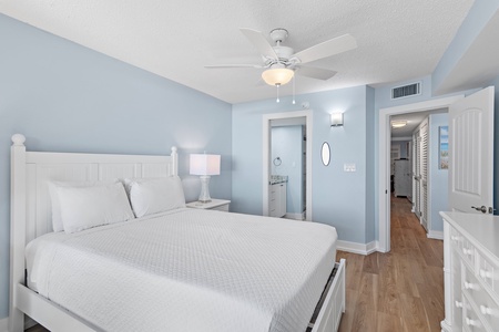 Drift off in your serene coastal bedroom, where soft blue walls and crisp white linens create a peaceful retreat after a day of sun and adventure.