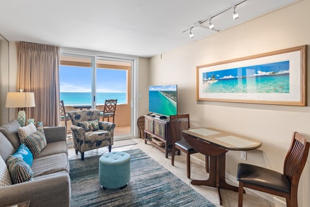 Your oceanfront living room features comfortable seating and stunning sea views through floor-to-ceiling windows, creating the perfect coastal retreat.