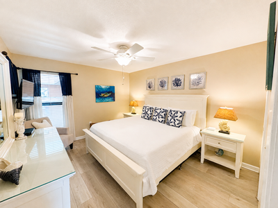 Sink into crisp linens and coastal calm in your peaceful bedroom retreat, where soft sea breezes from the ceiling fan and nautical touches help you unwind completely.
