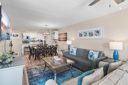 Relax in this bright oceanfront living space where coastal artwork and blue accents complement stunning sea views through your windows.
