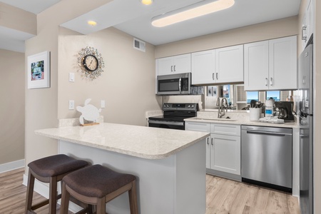 Relax in this bright oceanfront living space where coastal artwork and blue accents complement stunning sea views through your windows.