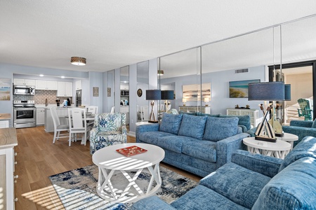 Settle into your spacious, coastal-inspired living area where plush blue sofas and elegant nautical decor create a soothing retreat after a day of exploring.
