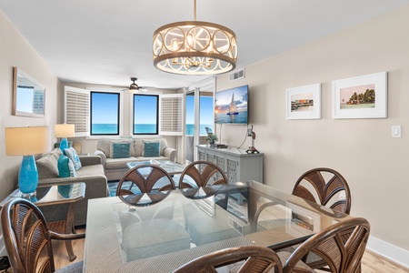 Your bright oceanfront living space features elegant coastal decor and stunning sea views through expansive windows.