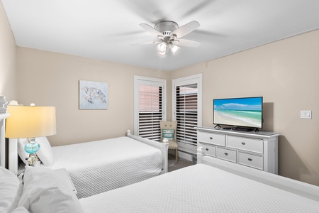 Drift off to sleep in this peaceful twin bedroom, where soft coastal breezes from the ceiling fan and beachside artwork create your perfect retreat.