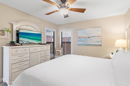 Your peaceful bedroom retreat features a plush bed, ceiling fan, and coastal artwork that brings the ocean indoors for restful nights.