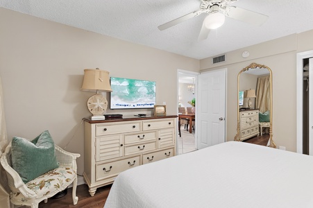 Your cozy coastal retreat features a plush bed, charming vintage furnishings, and beachy accents that invite restful nights. The elegant mirror and soft lighting create a calming sanctuary perfect for unwinding.