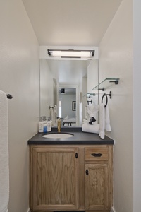 Your private bathroom vanity features modern black fixtures, a sleek countertop, and soft towels ready for your arrival—a perfect blend of comfort and style.
