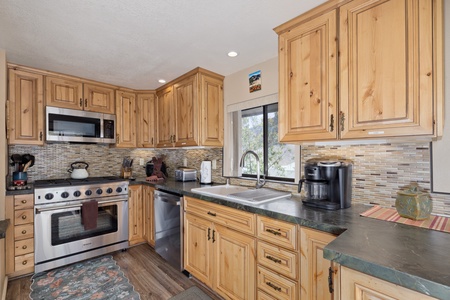 Your fully-equipped kitchen features warm wood cabinetry, granite countertops, and stainless steel appliances—perfect for preparing home-cooked meals during your stay.