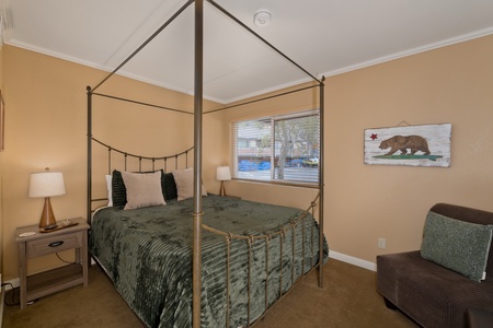 Drift off beneath the canopy bed's elegant frame, wrapped in soft, inviting linens. The warm California tones and cozy seating nook create your perfect retreat after a day of adventure.