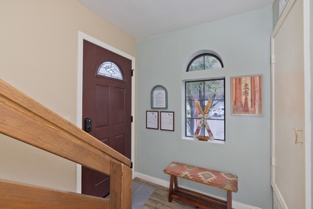 Step into a welcoming entry where natural light filters through arched windows and ski-themed art greets you. Your mountain getaway begins at this inviting threshold.