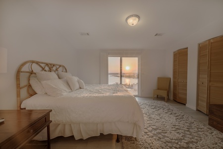 One of the two primary bedrooms featuring lakefront views, king-size bed, and en-suite bathroom