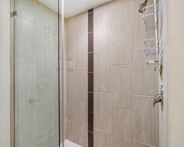 Experience a revitalizing shower in the walk-in shower with modern fixtures.