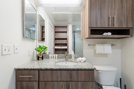 Freshen up in a spacious bathroom with ample storage and a walk-in shower, MALIN+GOETZ toiletries, plush bath towels, pool towels, a hairdryer, and hair straightener / flat iron