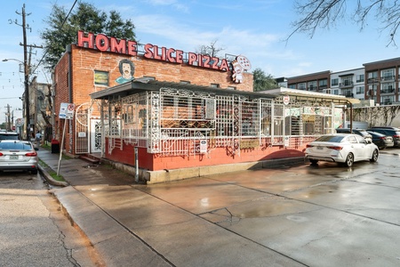 Home Slice Pizza, across the street from Mid Main Lofts: A beloved neighborhood pizzeria serving authentic New York-style pizza by the slice or pie, with a vibrant atmosphere and outdoor seating.