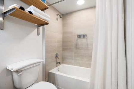Indulge in a relaxing bath in your private bathroom with a tub and toilet.
