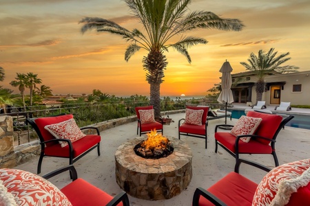 A lit fire pit and six chairs at Espiritu Casita 7