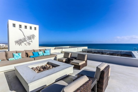 Rooftop seating of La Ribera House, complete with fireplace and couches.