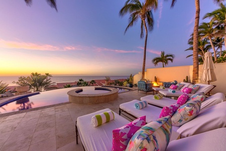 A view from the lounge chairs of the ocean at sunset.