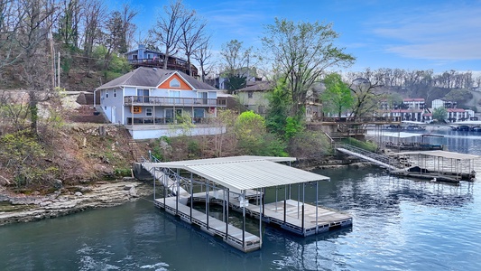 Scenic lakefront property with private dock and boat slip, nestled among mature trees in a peaceful waterfront community.