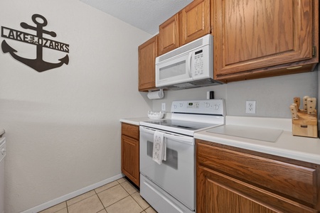Your fully equipped kitchen features everything you need, including a microwave, dishwasher, and smooth stovetop, all ready for your homemade meals during your Lake of the Ozarks getaway.