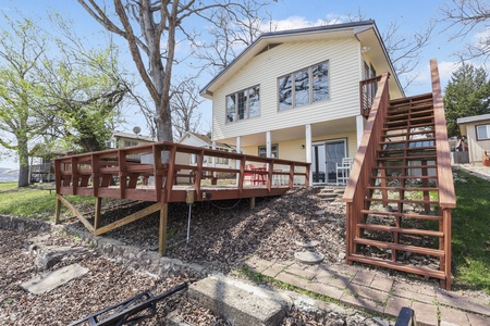 Charming waterfront cottage with elevated wooden deck offering scenic lake access and peaceful surroundings.