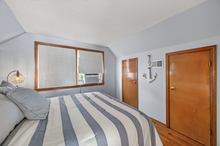 Drift off under vaulted ceilings in this cozy retreat, where nautical touches and soft natural light through the window create your own peaceful seaside haven.