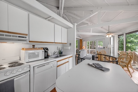 Picture yourself cooking in this bright open kitchen with vaulted ceilings and abundant natural light streaming through large windows overlooking lush greenery.