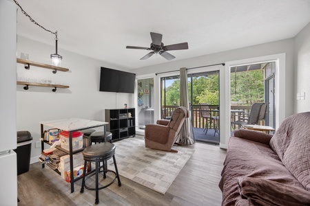 Unwind in your cozy living space with comfortable seating, smart TV, and sliding doors that open to your private balcony surrounded by lush greenery.