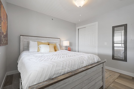 Sink into crisp white linens and golden accents in your peaceful bedroom retreat, where rustic charm meets modern comfort.