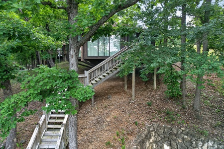 A peaceful treehouse-style retreat nestled among lush greenery, with rustic stairs leading to an elevated sanctuary where you'll feel close to nature.