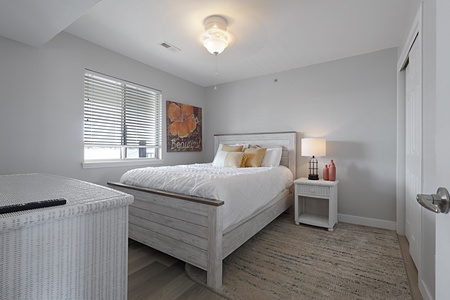 Unwind in your cozy bedroom featuring a plush queen bed, warm lighting, and thoughtful touches for peaceful nights.