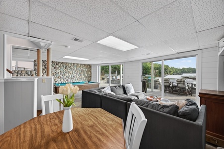 Settle into your spacious lakefront living room, where cozy sofas, a pool table, and fresh white tulips create the perfect blend of comfort and fun.