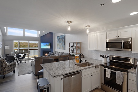 Your spacious open-concept haven features a gourmet kitchen with granite counters, cozy living area with fireplace, and stunning lake views.