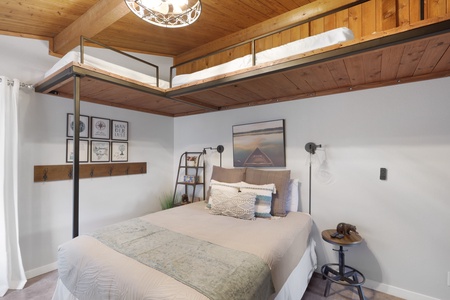 Drift into restful sleep beneath vaulted wood ceilings and soft lighting, with serene artwork and cozy linens inviting your peaceful retreat.