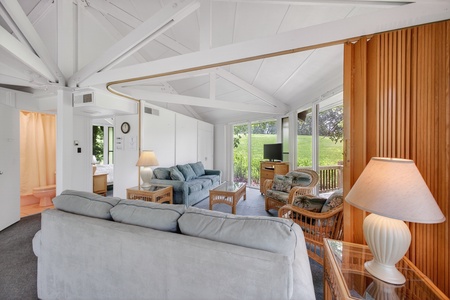 Relax in this bright, open living space with vaulted ceilings and large windows framing peaceful green views. Sink into plush seating and let natural light fill your stay.