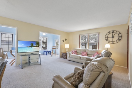 Relax in your spacious living room with plush seating and large TV for cozy movie nights after exploring.