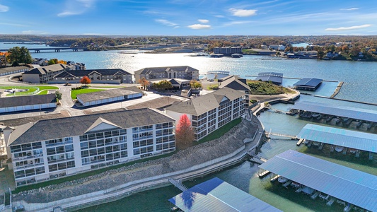 Lakefront resort property with marina facilities and autumn foliage, situated on scenic waterfront with boat docks and surrounding residential area.