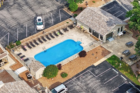 Aerial overview of the property featuring a sparkling outdoor pool, spacious lounging area with multiple sunbeds, and private parking—ideal for a relaxing getaway.