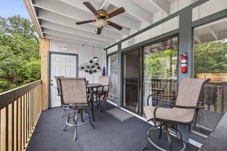 A private screened balcony with a cozy table and chairs, surrounded by treetops—perfect for your morning coffee or evening unwind.