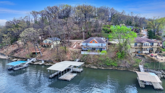 Lakefront property with private dock and boat slip in peaceful wooded neighborhood setting.