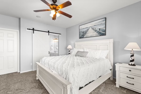 Your peaceful coastal bedroom awaits with crisp white linens, nautical touches, and gentle ceiling fan breezes for ultimate comfort.
